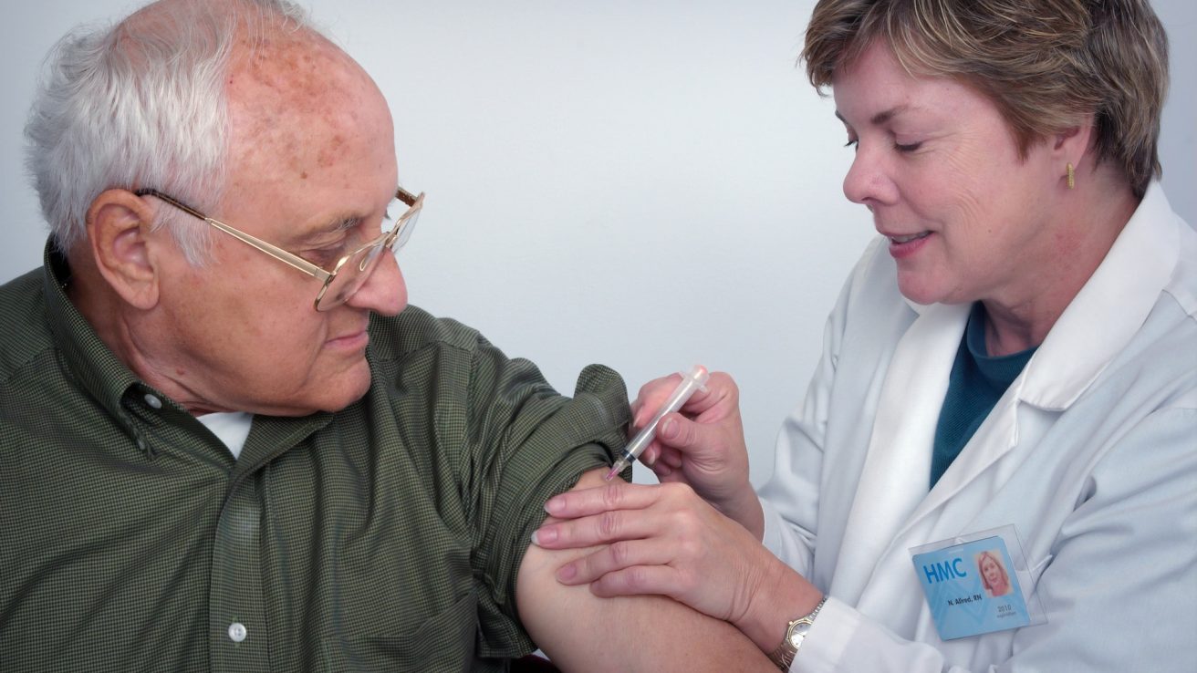 a geriatric patient receiving a vaccination from a healthcare provider