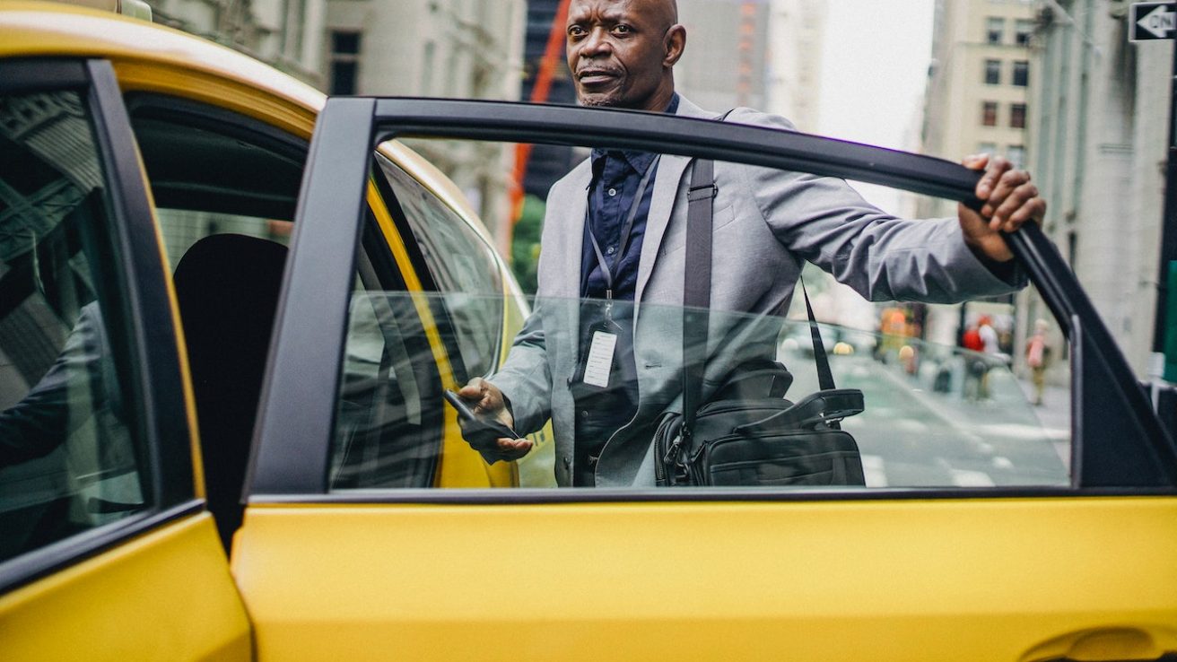 a black businessman entering a taxi