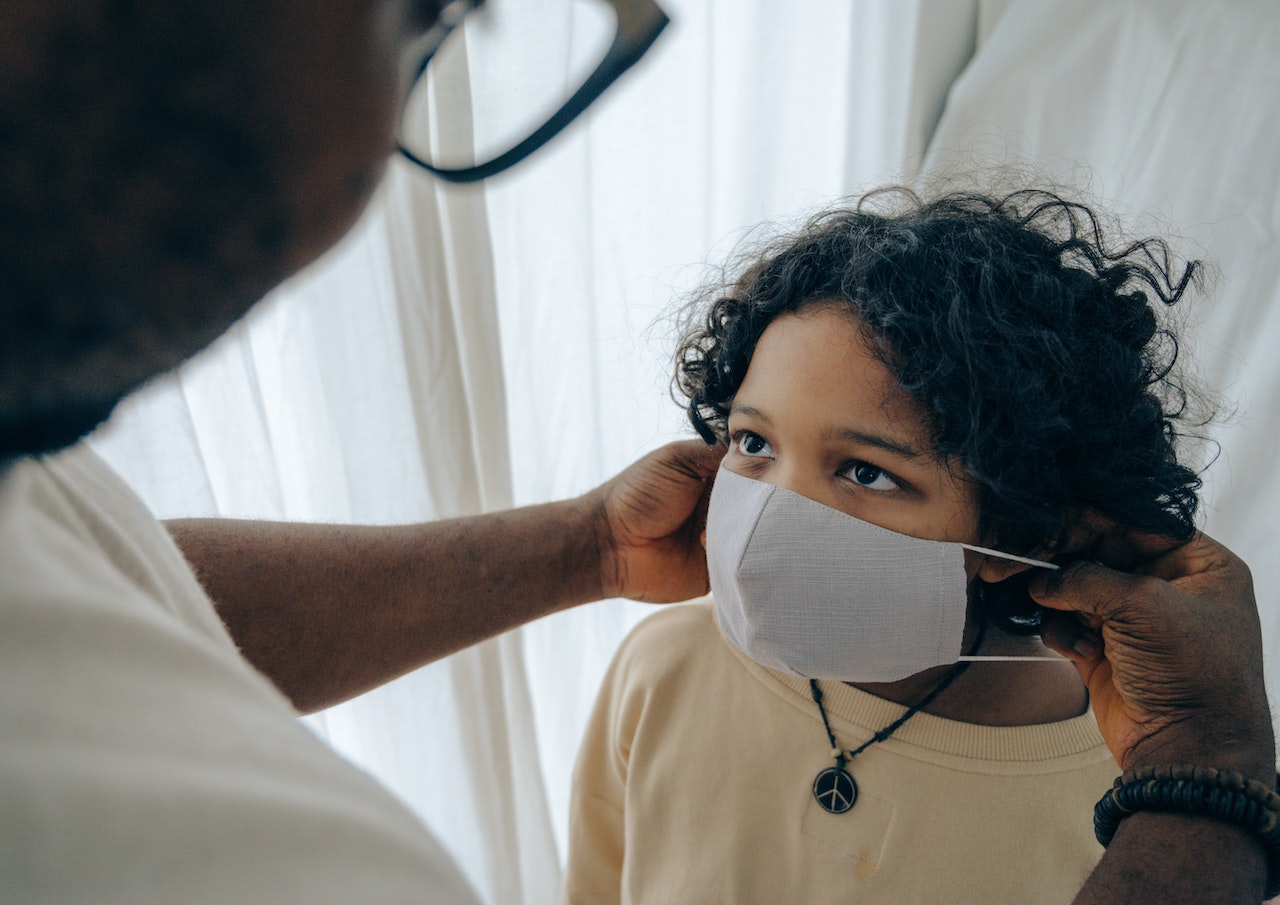 A doctor putting a mask on a patient 