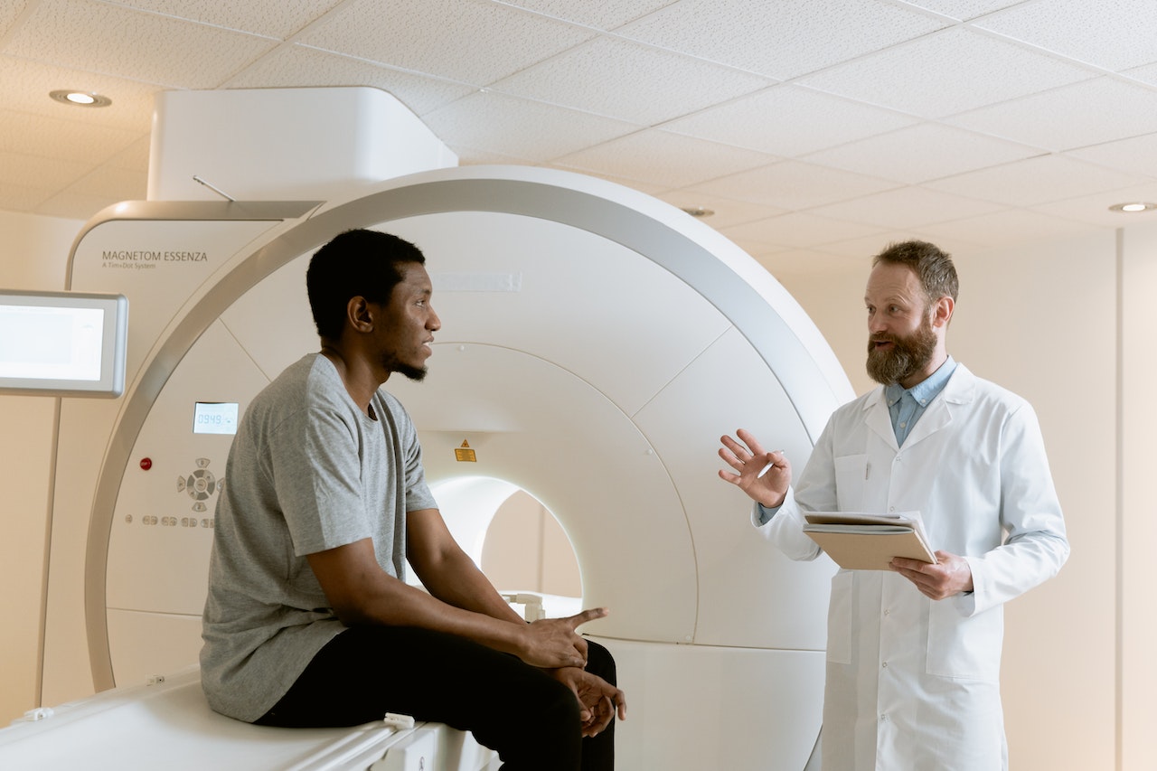 Man and doctor talking in front of a medical imaging device