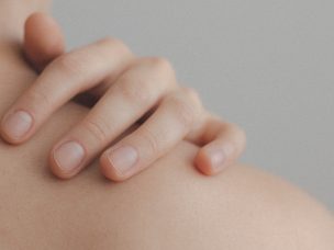 Close-up of a person touching their shoulder