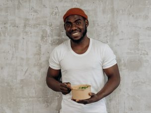 a man in a white shirt eating a salad